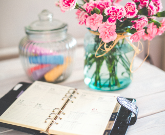 Calendar planner with bouquet of pink carnations in a vase