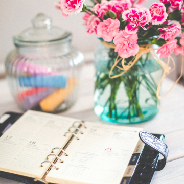 Calendar planner with bouquet of pink carnations in a vase